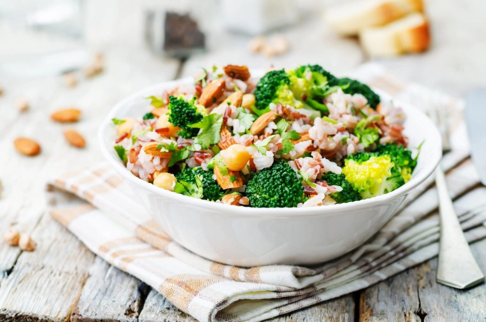 A bowl of broccoli and rice on top of a table.