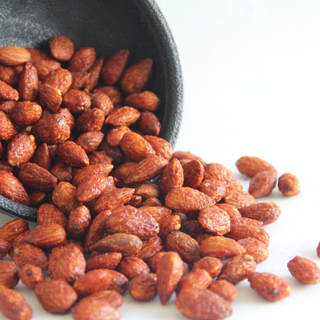 A bowl of peanuts is shown with the lid off.