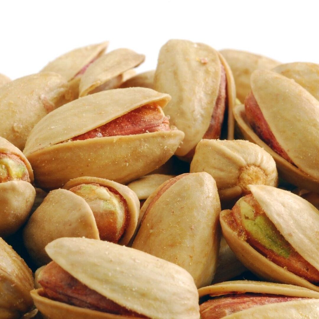 A pile of pistachios sitting on top of each other.